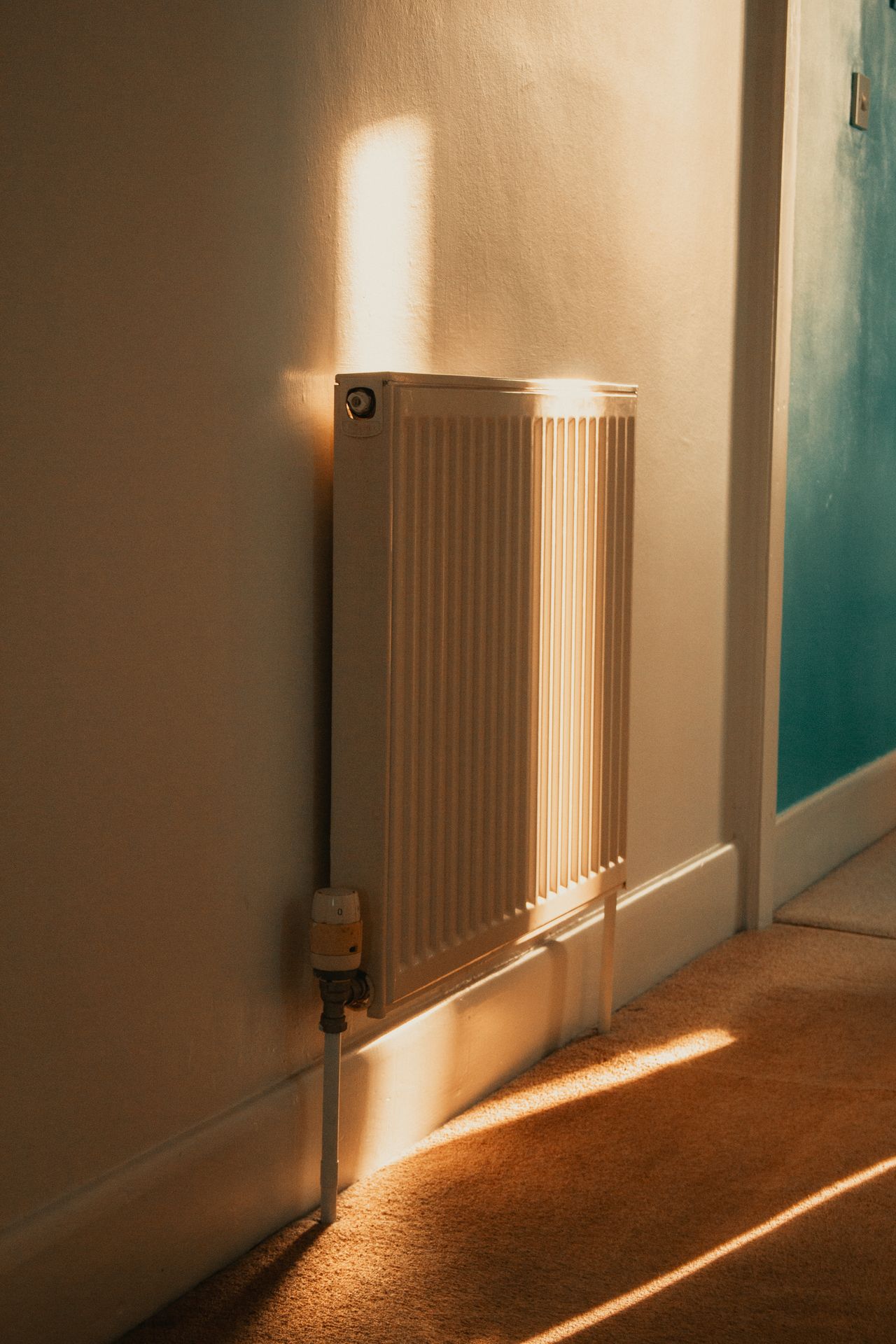 Hand draait de thermostaatknop van een radiator hoger